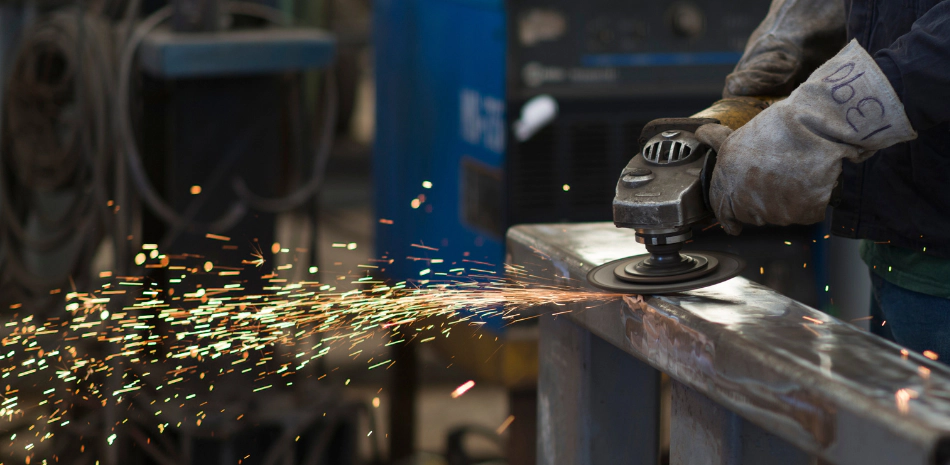 a hand using an angle grinder as part of the fabrication steps
